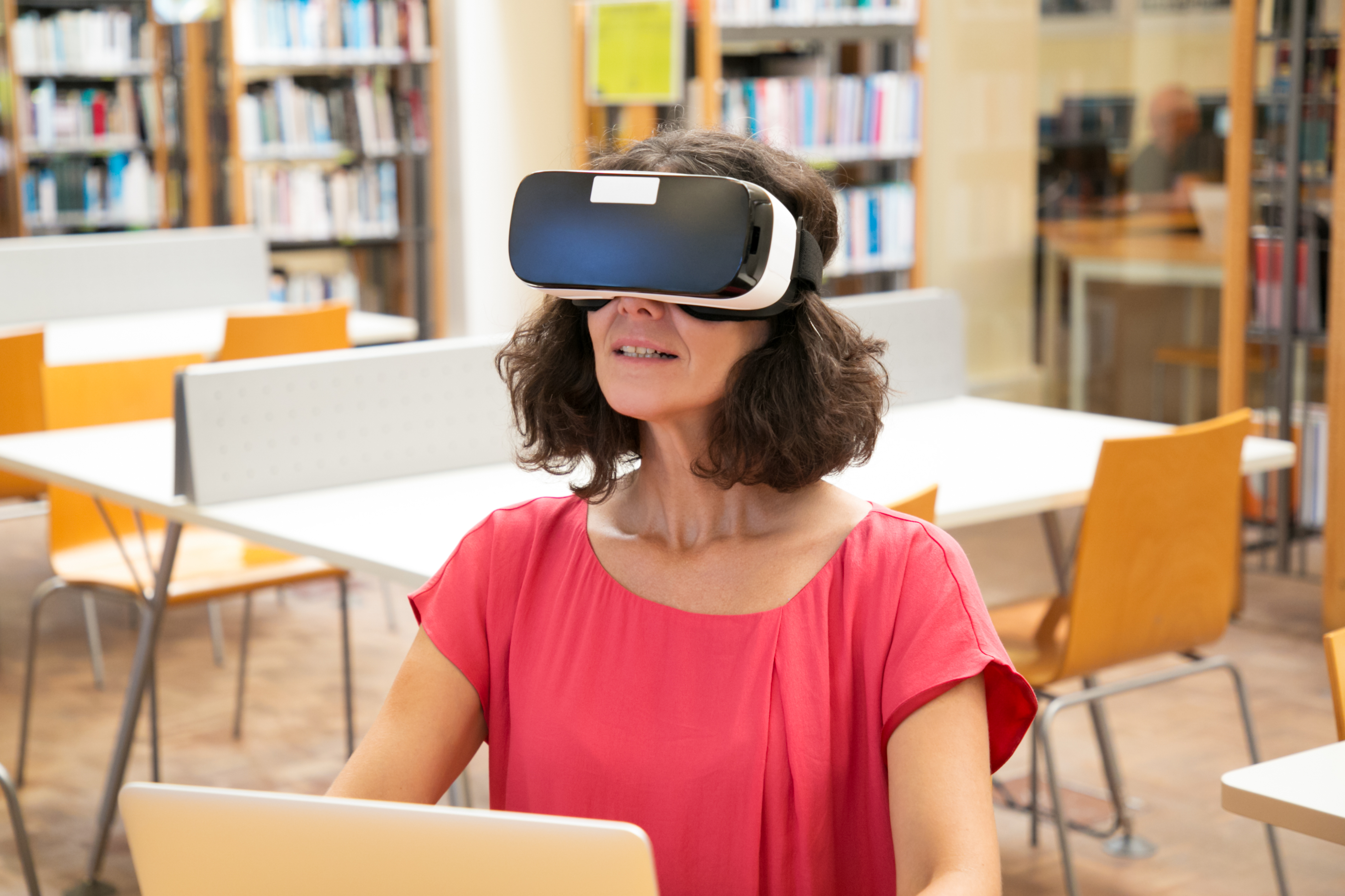 Studentica sjedi u predavaonici i koristi VR naočale 