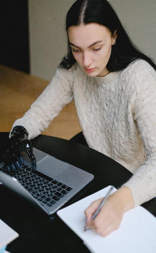 Osoba piše na laptopu s protetičkom šakom.