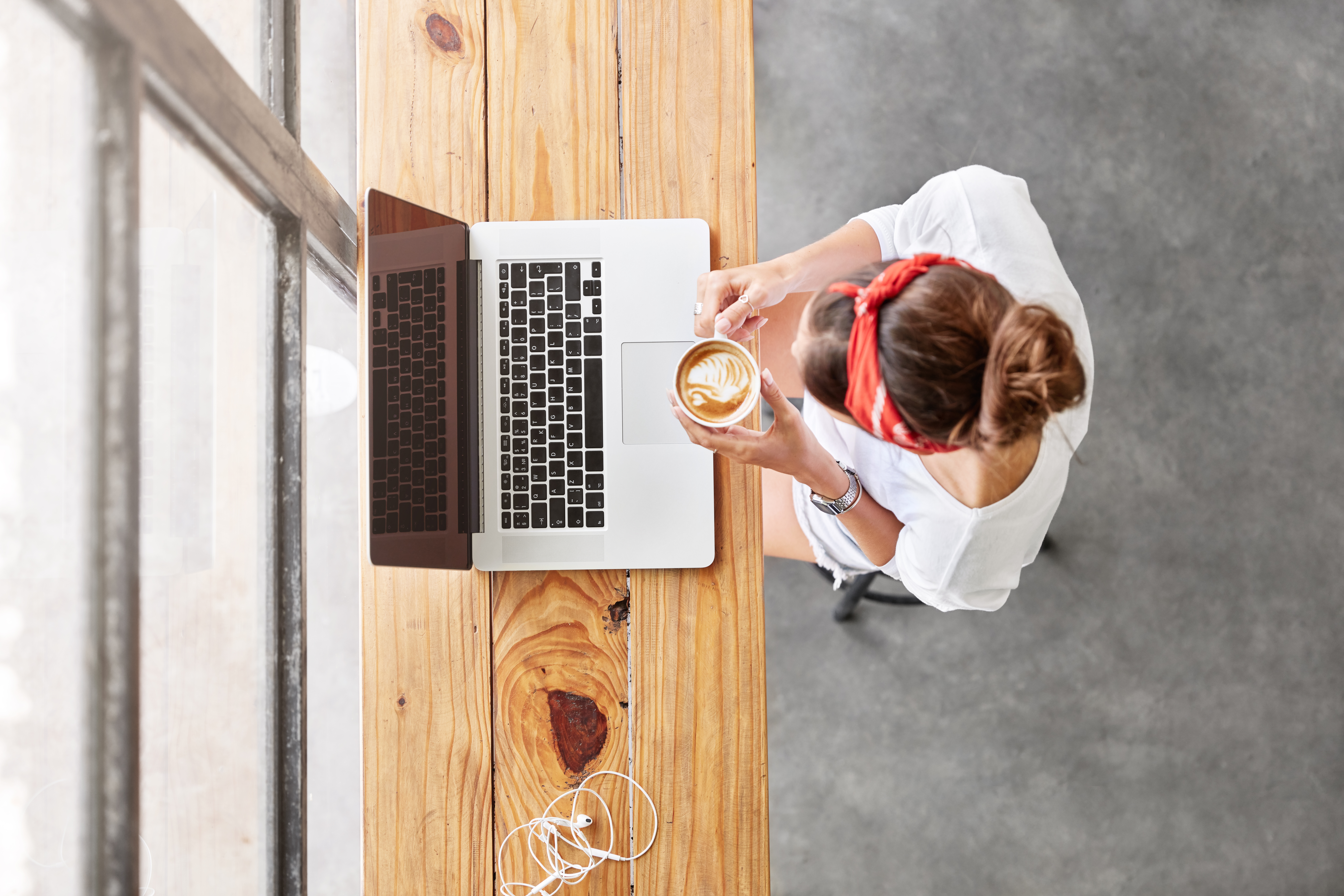Student sitting at a laptop, working and drinking coffee