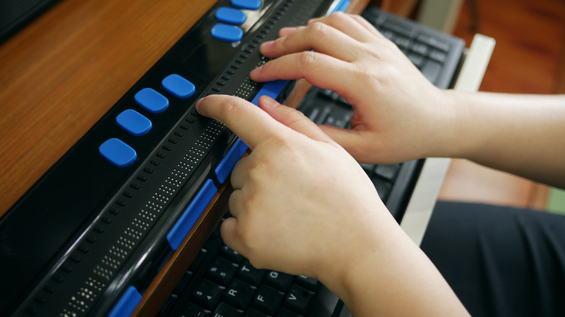 A person with vision loss using a Braille display.