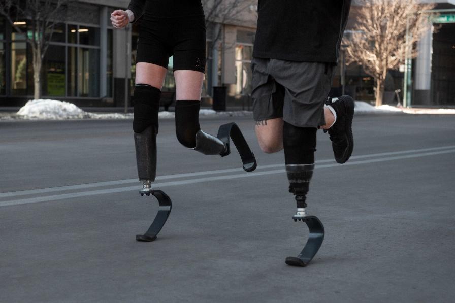 Two individuals with running blades are running along the street.

AI-generated content may be incorrect.